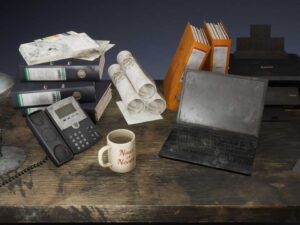 Dirty office accessories a laptop folders a printer a phone papers etc